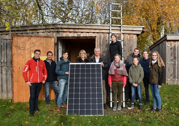 Gruppenbild mit PV-Modul vor dem grünen Klassenzimmer: Maximilian Griebenow, Stadtwerke Soest – Jens Galle, Firma Hans Stahl – Thorben Göhr, Bio-Lehrer Convos – Judith Olschewsky, Bio-Lehrerin Convos – Ulrich Dellbrügger, Bio-Lehrer Convos – Lara, Hanna, Jonas, Lea, Jasin, Antonia (Schüler des Convos)